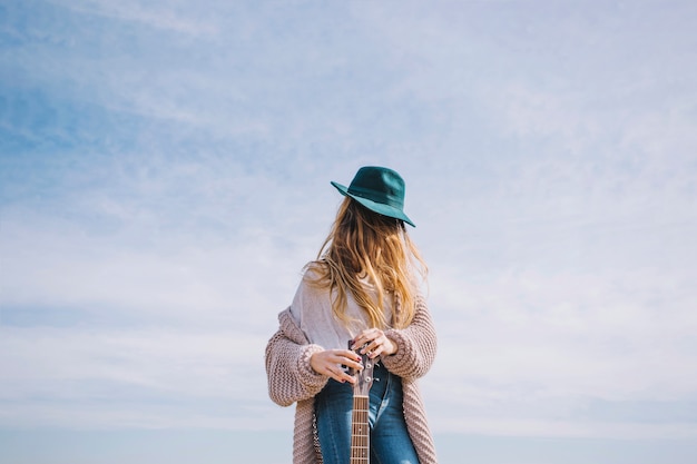 Femme avec guitare dans la campagne