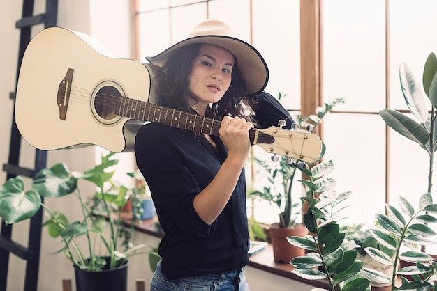 Femme avec guitare sur l&#39;épaule