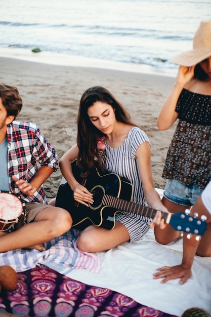 Femme avec guitare à la plage