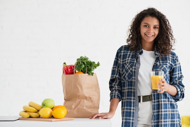 Photo gratuite femme habillée décontractée assise à côté d'un sac de légumes