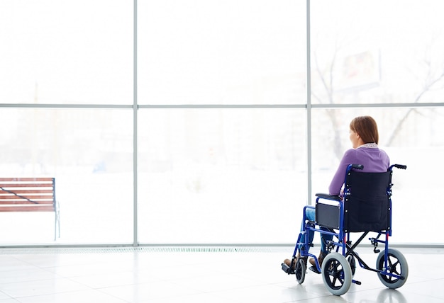 Femme handicapée en regardant la fenêtre