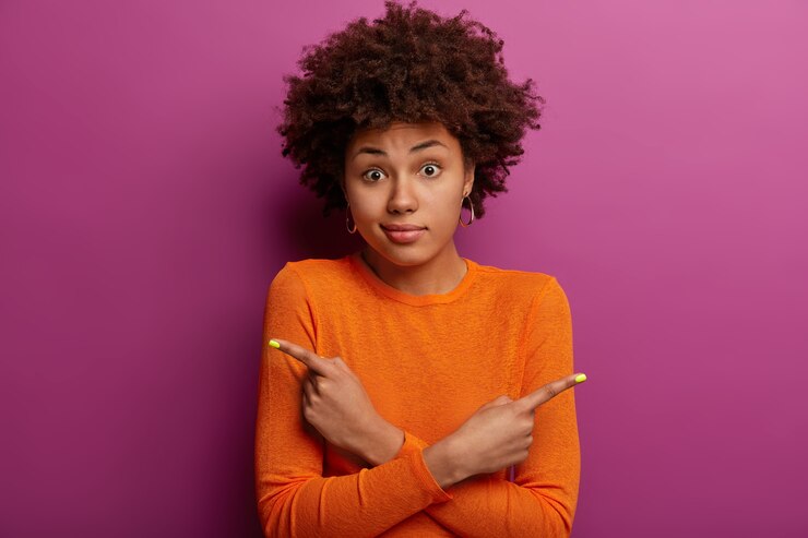 Photo gratuit femme hésitante inconsciente avec une coiffure frisée croise les mains sur la poitrine