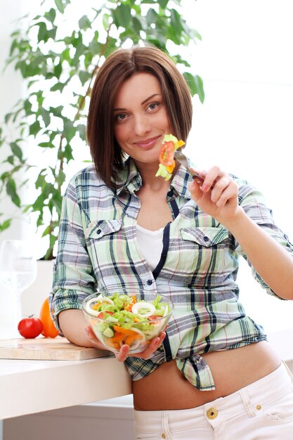 Femme heureuse avec bol de salade fraîche