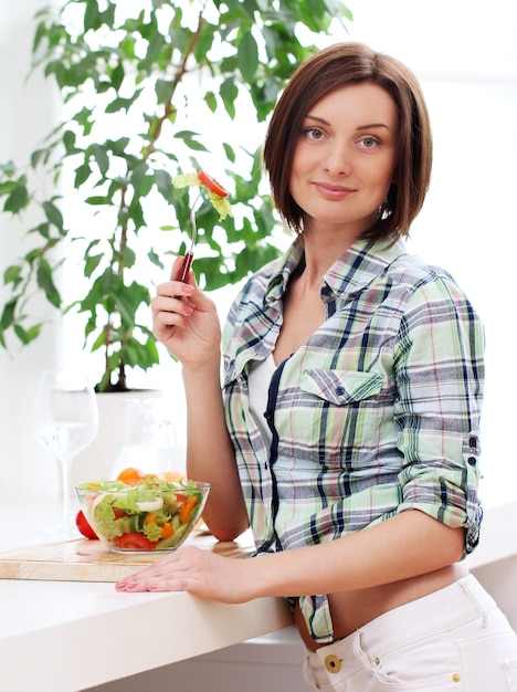 Femme heureuse avec bol de salade fraîche