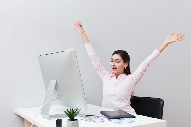 Femme heureuse, bureau, regarder ordinateur