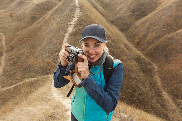 Photo gratuite femme heureuse avec caméra à l'extérieur