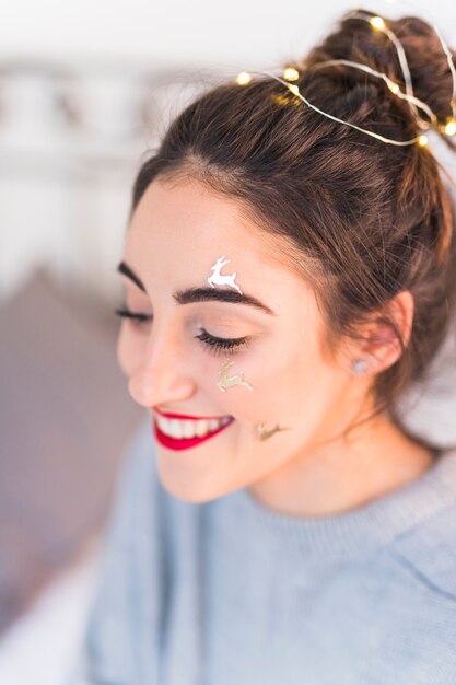 Femme heureuse avec cerf paillettes sur le visage