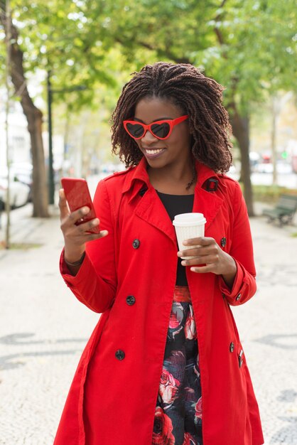 Femme heureuse, dans, lunettes soleil, utilisation, smartphone