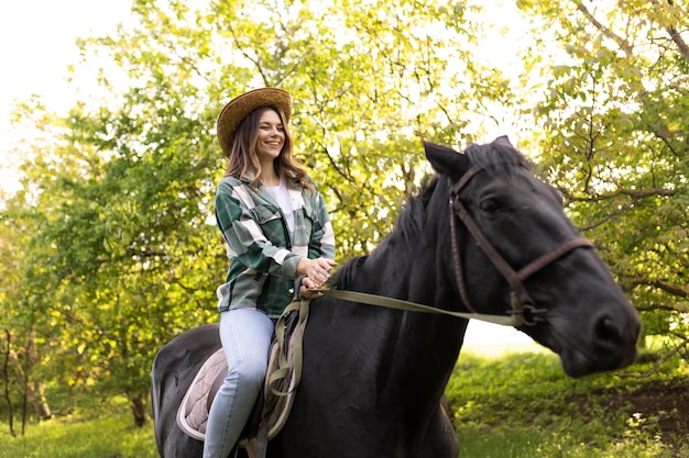 Femme heureuse équitation cheval coup moyen