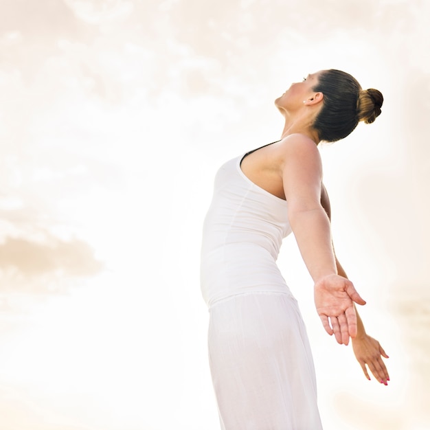 Photo gratuite femme heureuse faisant du yoga sous le soleil