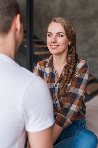 Femme heureuse avec homme amoureux assis à l&#39;intérieur