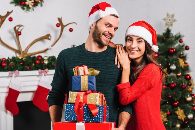 Femme heureuse et homme avec de nombreux cadeaux