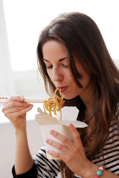 Femme heureuse, manger nouilles