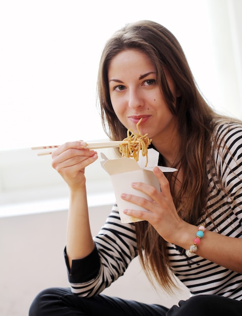 Femme heureuse, manger nouilles