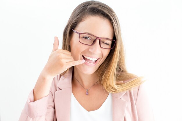 Femme heureuse montrant un geste d&#39;appel et un clin d&#39;œil