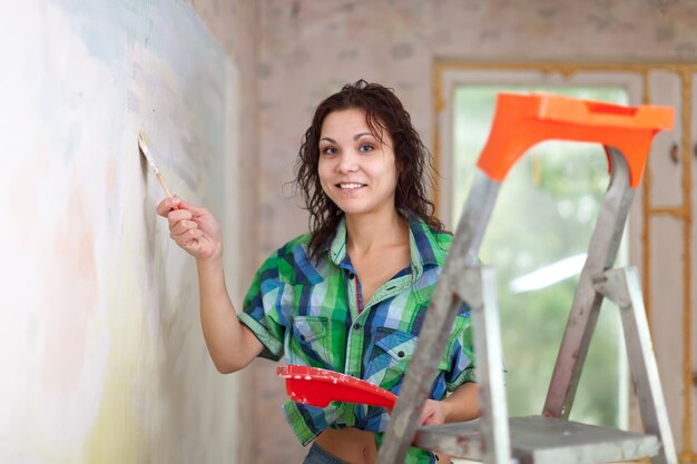 Femme heureuse peint le mur