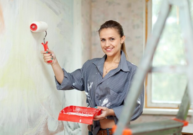 Femme heureuse peint le mur