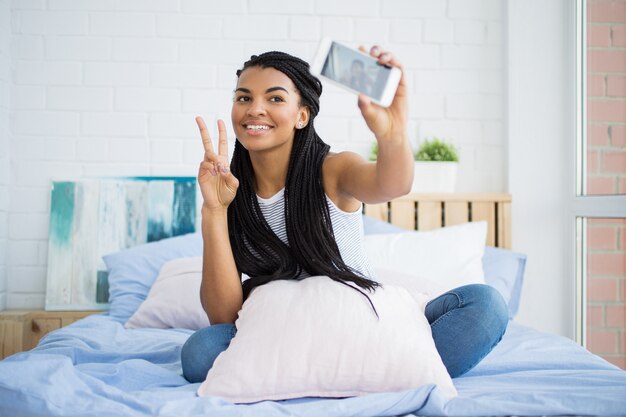 Femme heureuse prenant le selfie montrant un geste de cornes