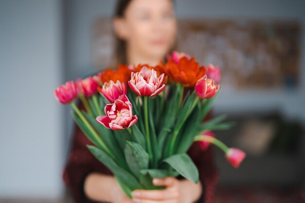 Femme heureuse profitez d'un bouquet de tulipes Femme au foyer bénéficiant d'un bouquet de fleurs et de l'intérieur de la cuisine