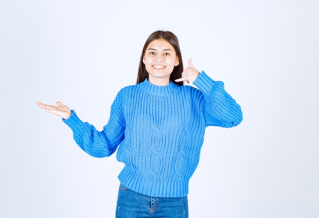 femme heureuse en pull bleu debout sur blanc.