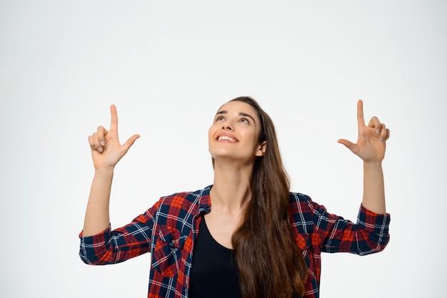 Femme heureuse rêveuse pointant vers le haut