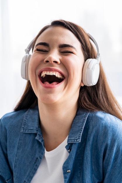 Femme heureuse en riant et en écoutant de la musique au casque