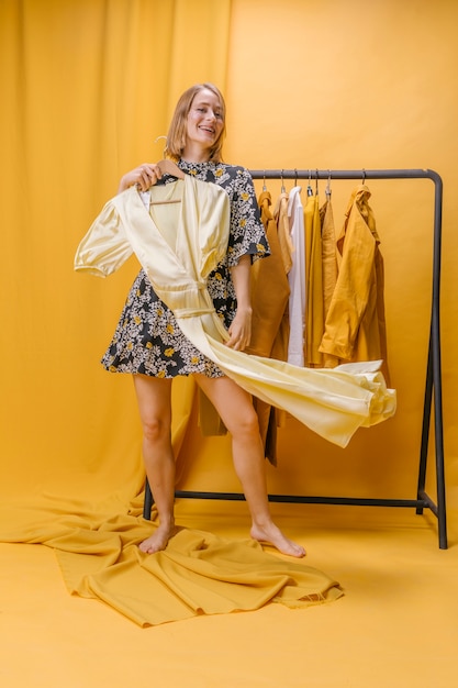 Photo gratuite femme heureuse avec une robe en scène jaune