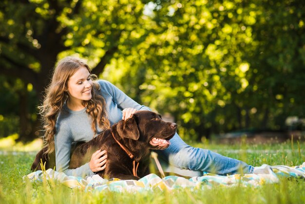 Femme heureuse s&#39;amuser avec son chien dans le jardin