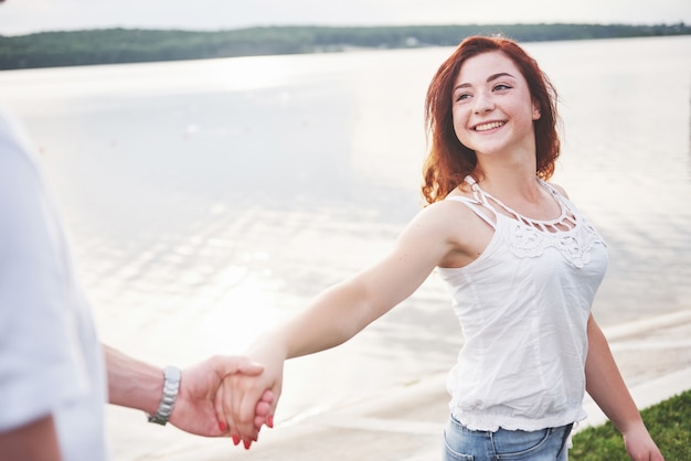 Une femme heureuse souriante avec une expression ludique et une main avec son mari.