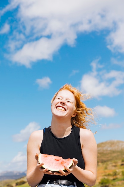 Photo gratuite femme heureuse avec une tranche de melon d'eau