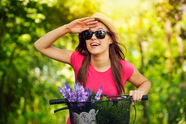 Femme heureuse avec vélo en regardant quelque chose