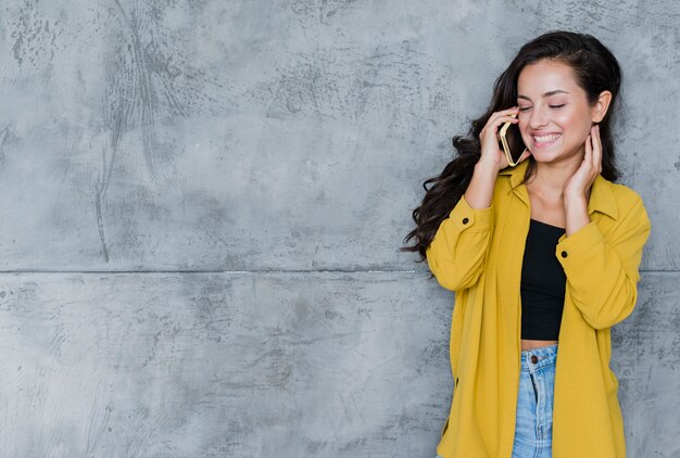 Femme heureuse vue de face, parler au téléphone