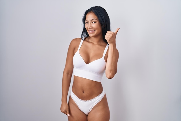 Photo gratuite femme hispanique portant de la lingerie faisant un geste de pouce levé heureux avec une expression d'approbation de la main regardant la caméra montrant le succès