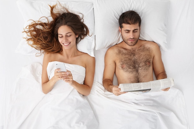 Femme et homme assis dans le lit vue de dessus