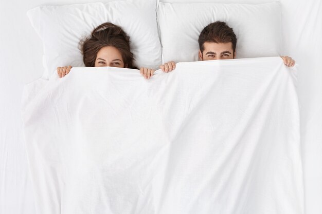 Femme et homme assis dans le lit vue de dessus