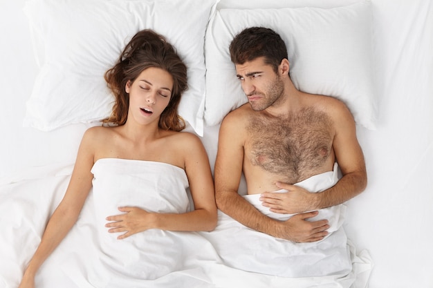 Femme et homme assis dans le lit vue de dessus