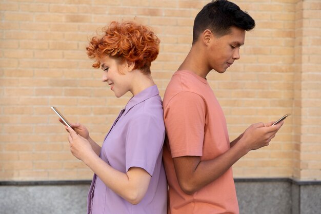 Femme et homme de coup moyen avec des téléphones