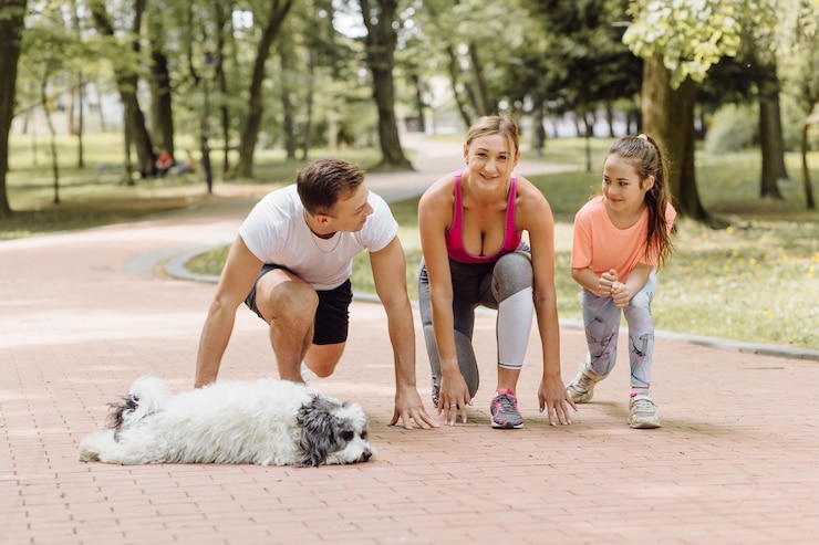 Photo gratuit femme, homme et petite fille vont courir avec leur chien dans le parc