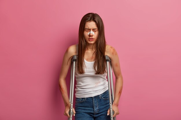 Une femme hospitalisée a une période de rééducation après un accident grave, diverses fractures, pose sur des béquilles, souffre d'une grave maladie de la colonne vertébrale, est blessée après un accident de voiture, a un saignement de nez cassé