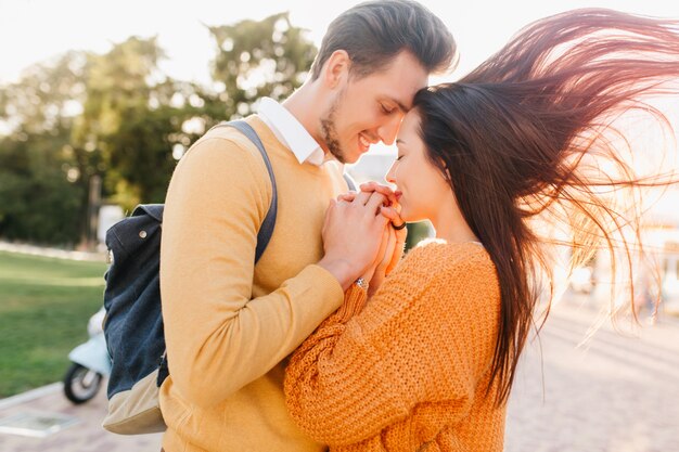 Femme incroyable aux longs cheveux bruns en agitant main dans la main avec un homme barbu sur fond de nature