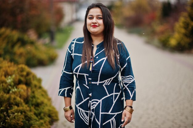 Femme indienne brune en robe longue à la mode posée en plein air