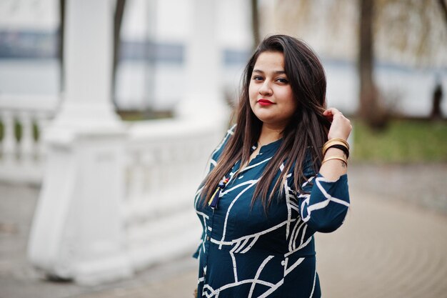 Femme indienne brune en robe longue à la mode posée en plein air