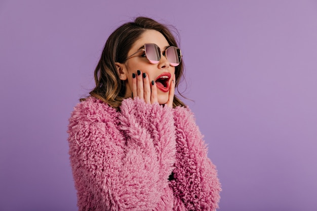 Femme intéressée posant dans des lunettes de soleil