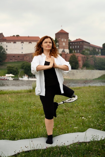 Femme avec jambe prothétique faisant du yoga