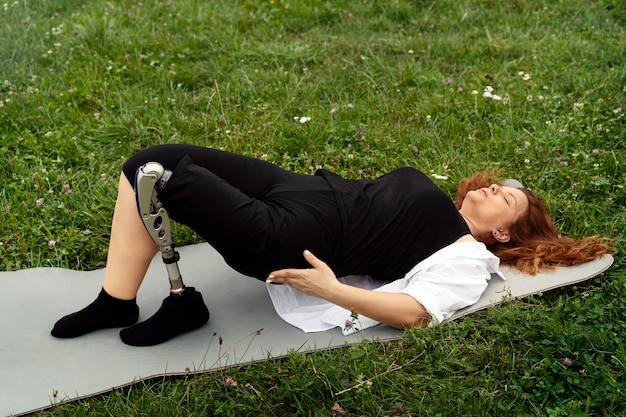 Femme avec jambe prothétique faisant du yoga