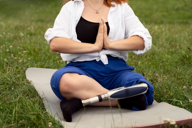 Femme avec jambe prothétique faisant du yoga