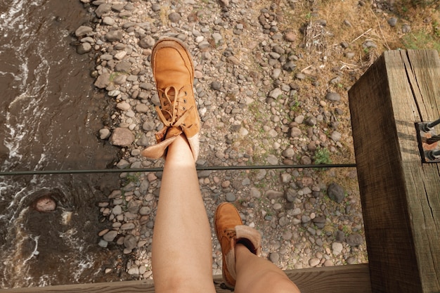 Femme jambes assis sur le bord du pont