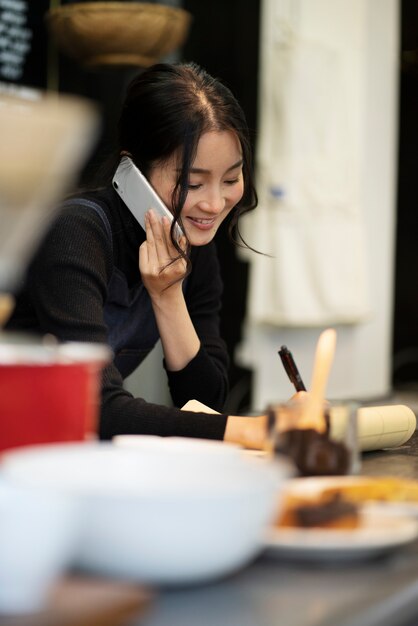 Femme japonaise parlant sur smartphone dans un restaurant