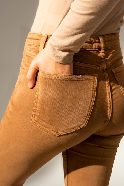Femme en jeans marron avec la main rentrée dans la poche