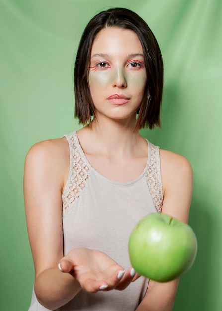 Femme jetant une pomme en posant